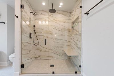 A bathroom with a walk in shower and a toilet.