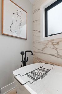 There is a picture of a woman on the wall above the bathtub.