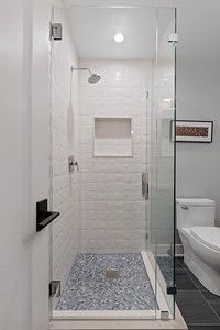 A bathroom with a walk in shower and a toilet.