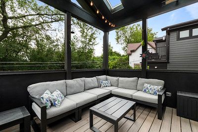 A patio with a large sectional couch and a coffee table.