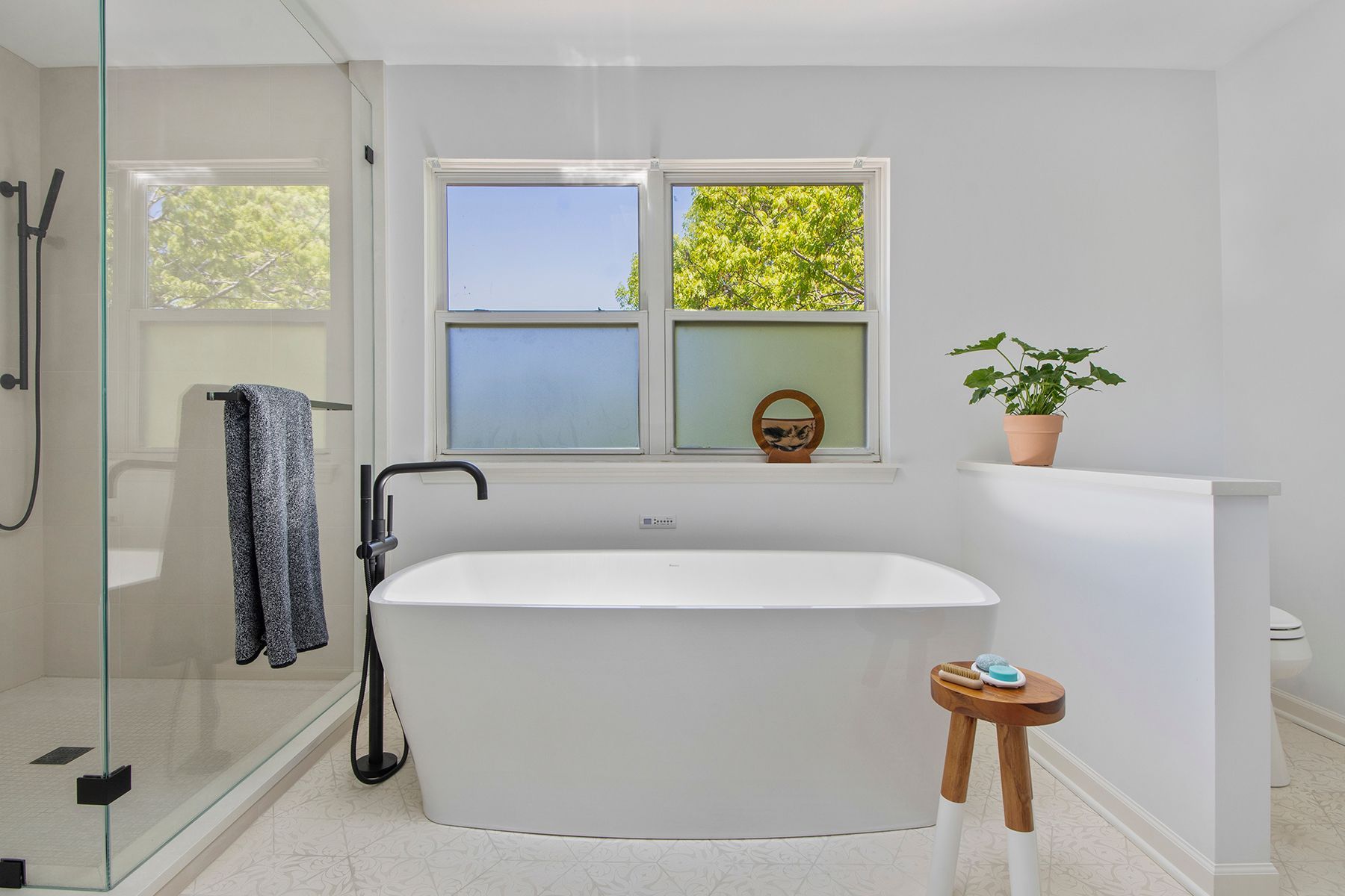 A bathroom with a tub , shower , and window.
