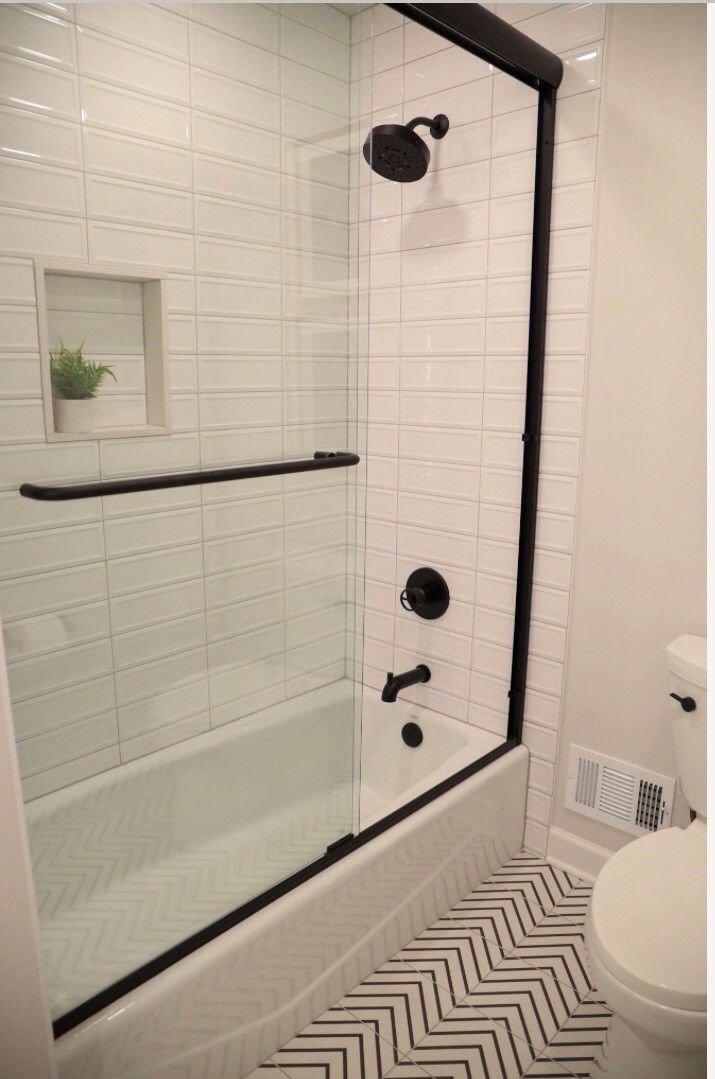 A bathroom with a bathtub , toilet and shower.