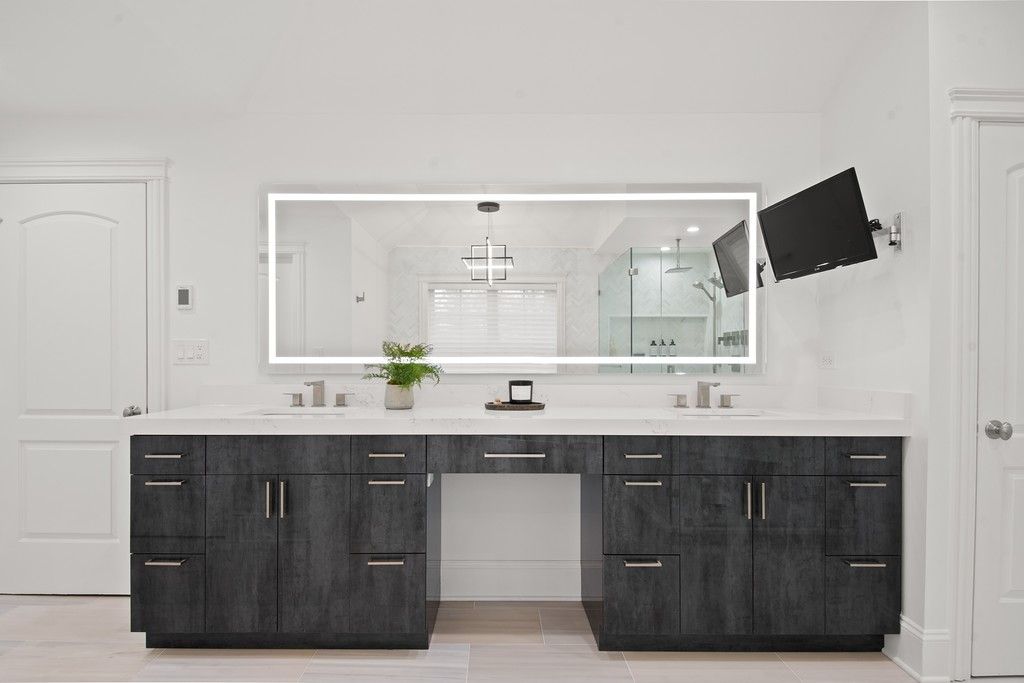 A bathroom with two sinks and a large mirror.