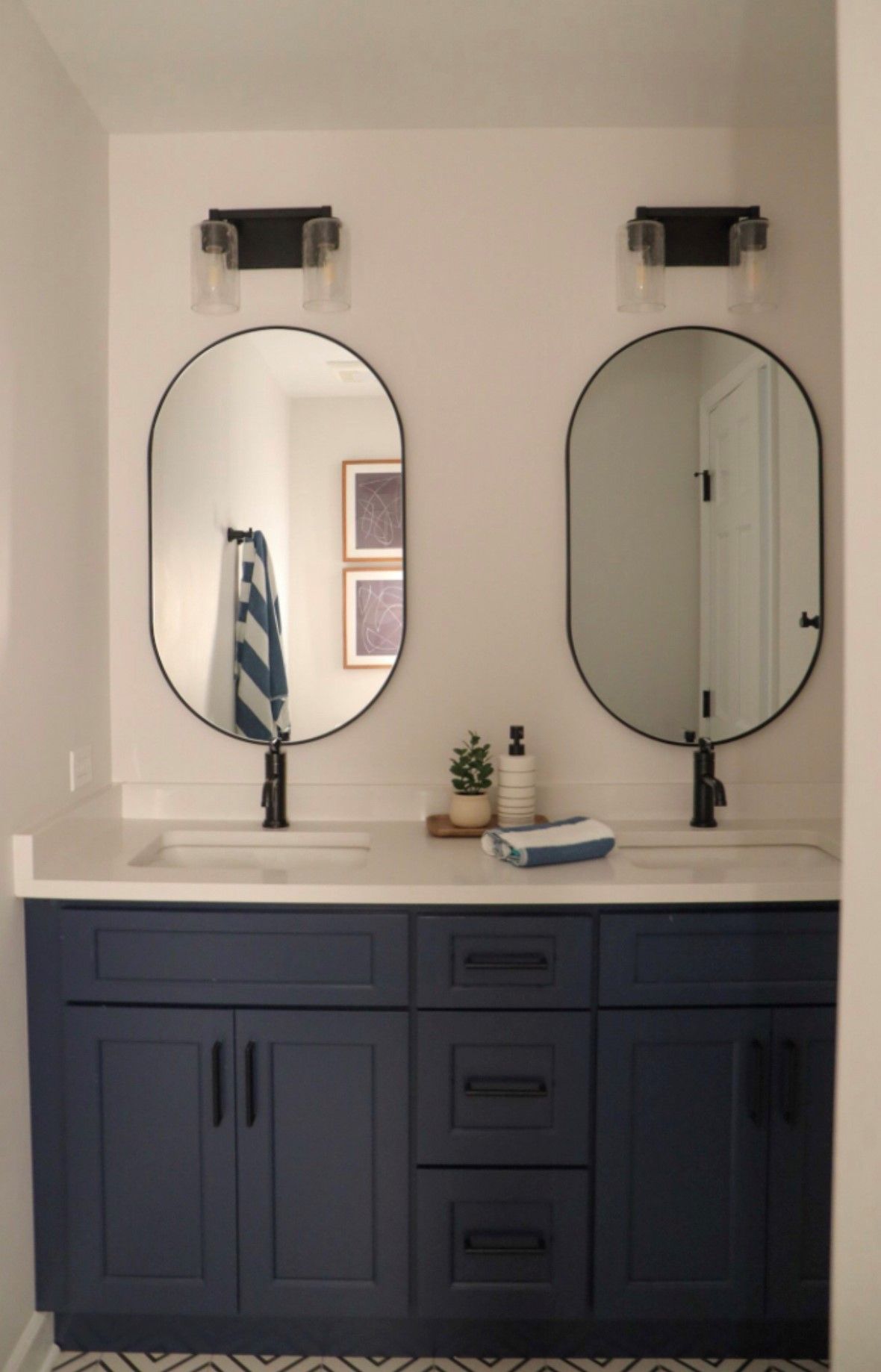 A bathroom with two sinks and two mirrors.