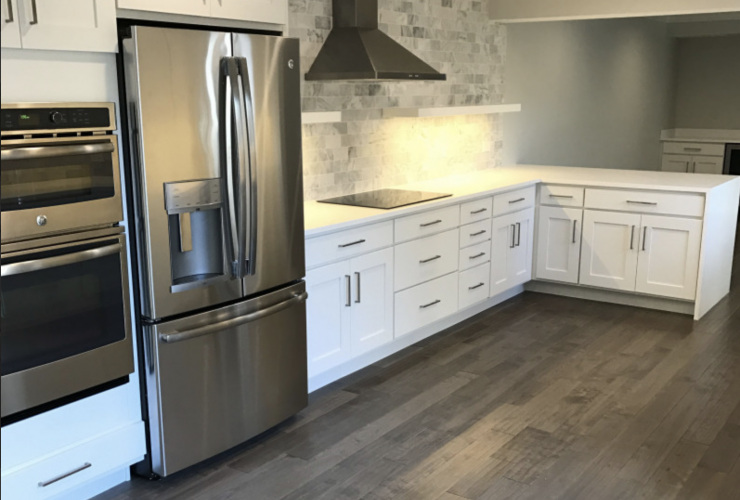 A kitchen with stainless steel appliances and white cabinets