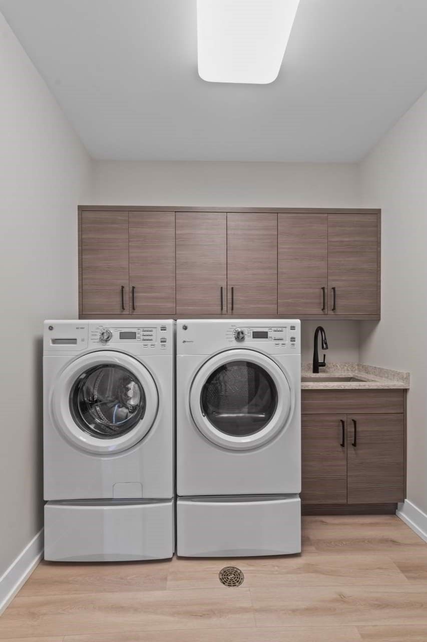 A laundry room with a washer and dryer and a sink.