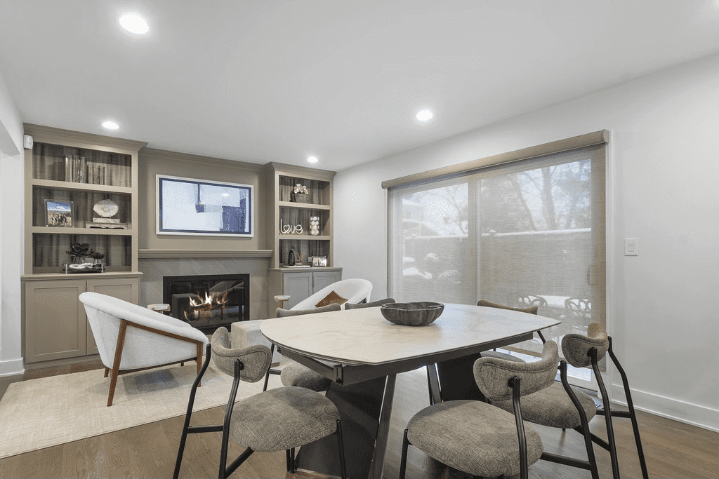 A living room with a table and chairs and a fireplace.