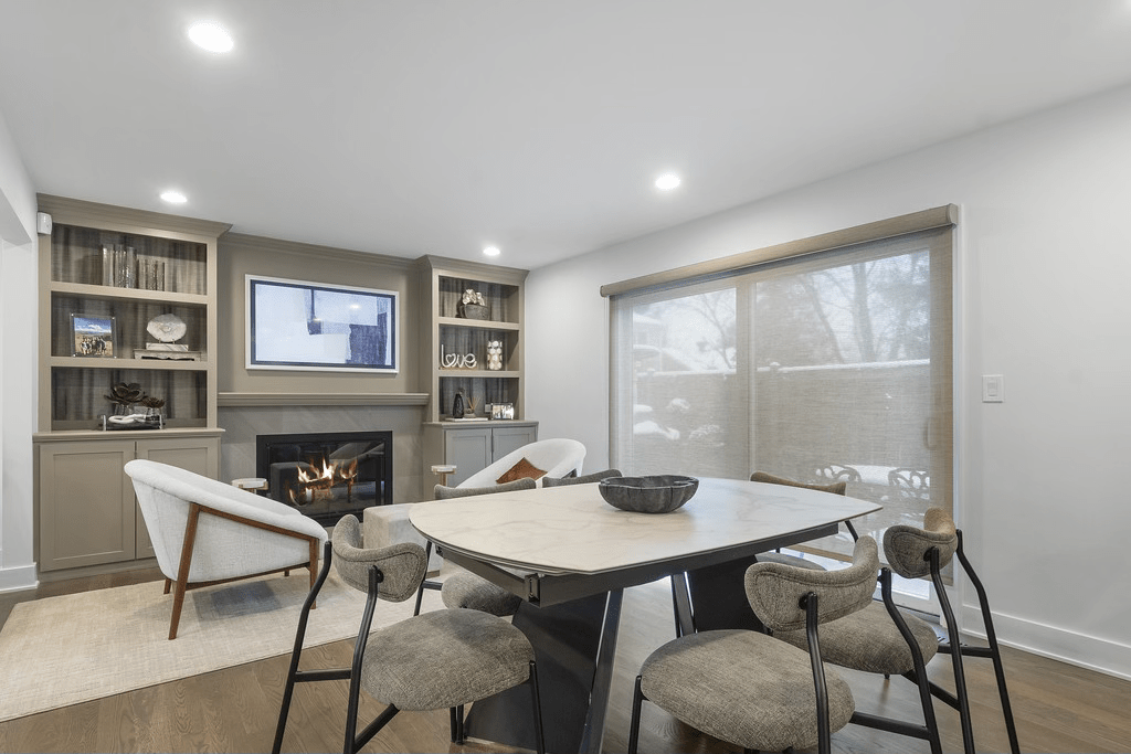 A living room with a table and chairs and a fireplace