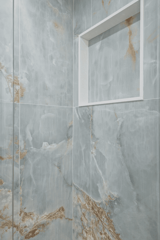 A bathroom with a shower stall and a shelf in the wall.