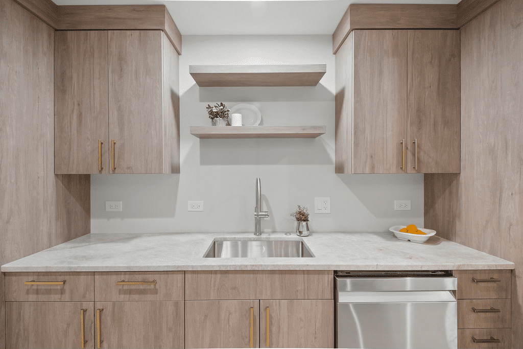 A kitchen with wooden cabinets , a sink , and a dishwasher.