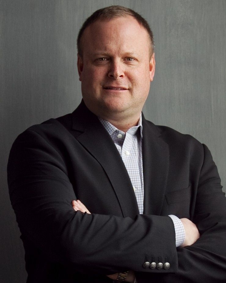 A man in a suit is standing with his arms crossed