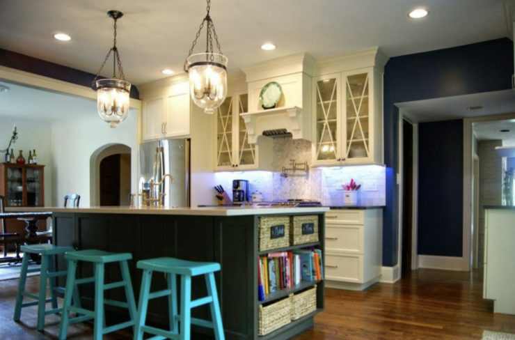 A kitchen with a large island and blue stools