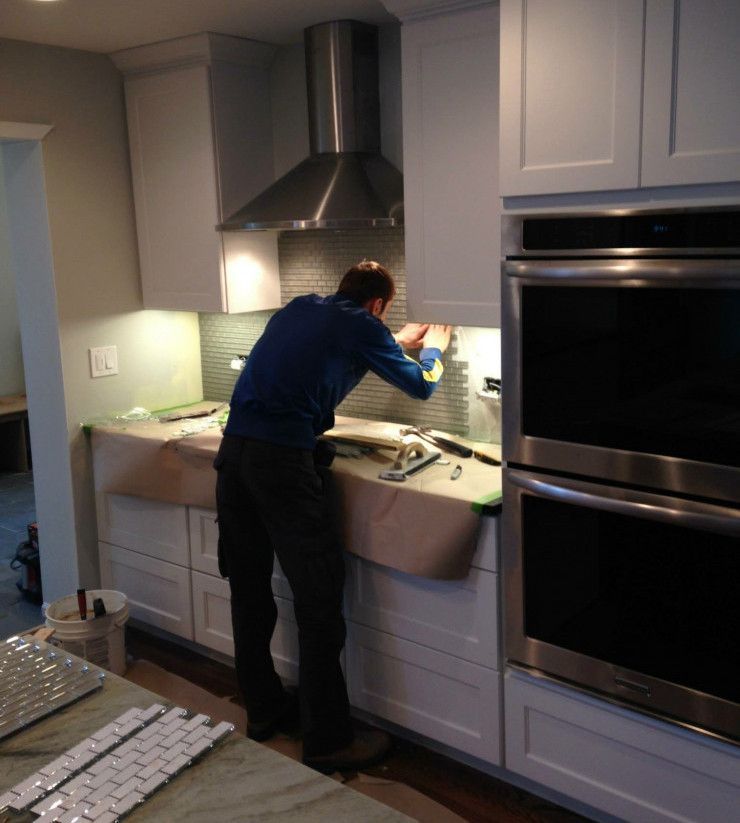 A man in a blue shirt is working in a kitchen