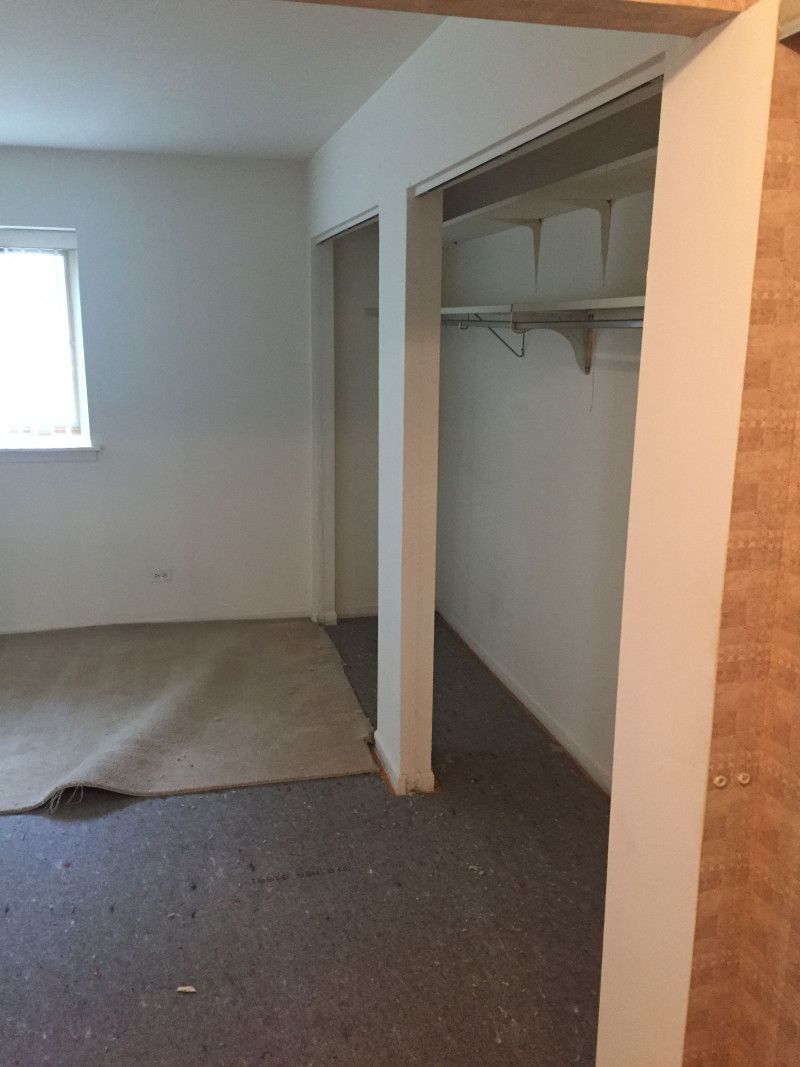 An empty room with a closet and a window