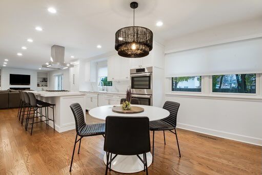A dining room with a round table and chairs in a kitchen.