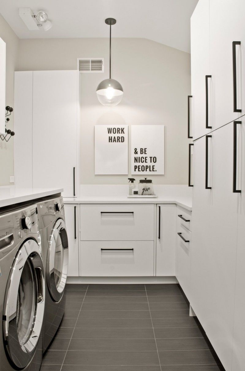 A laundry room with a washer and dryer and white cabinets.
