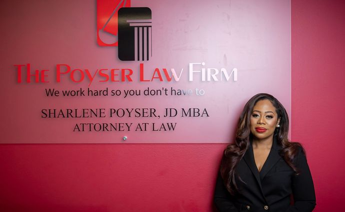 a woman is standing in front of a sign for a law firm .