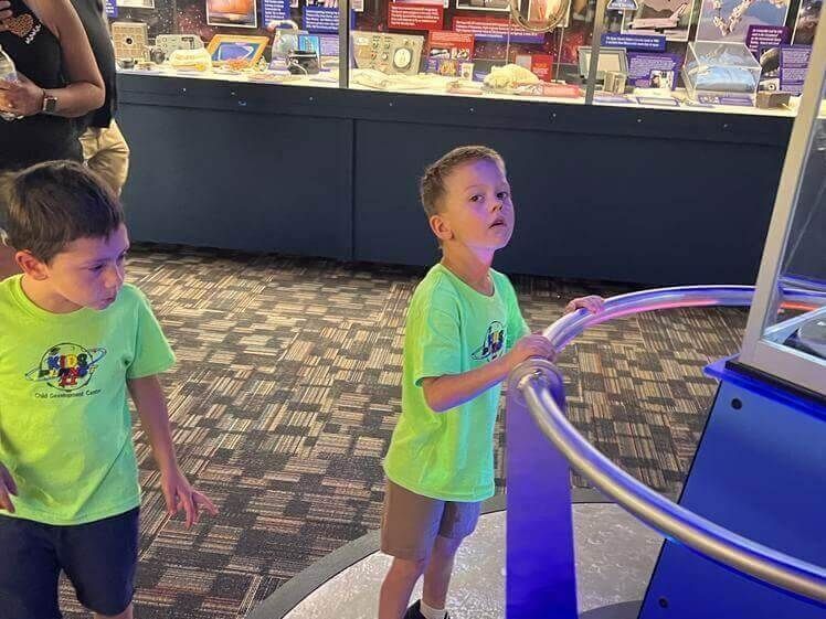 Two young boys are looking at a display in a museum.