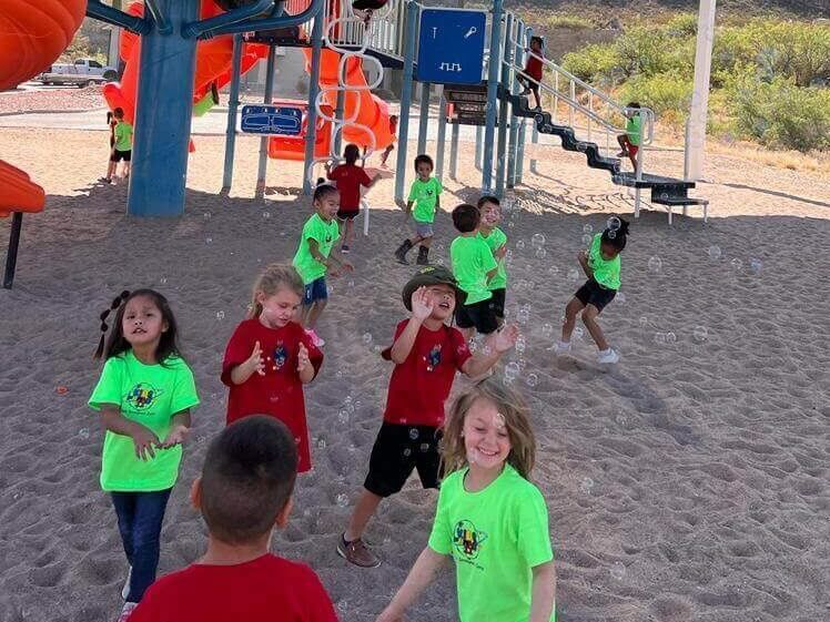 A group of children are playing in the sand at a playground