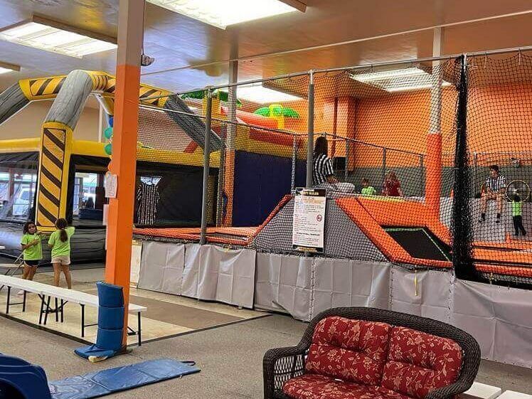 A trampoline park with a couch and a slide.