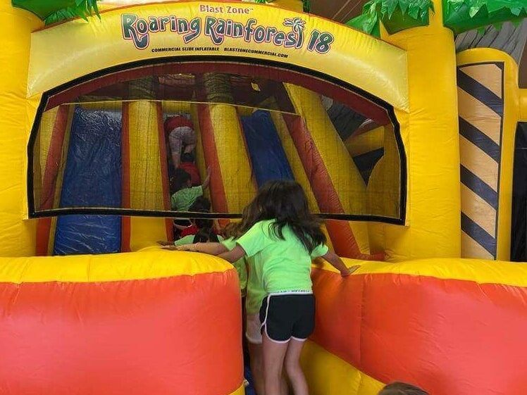 A little girl is playing in an inflatable bouncy house.