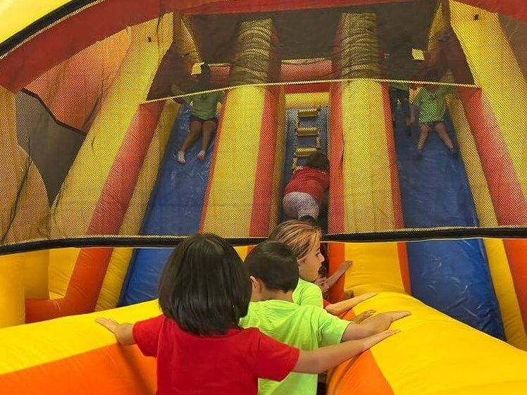 A group of children are playing on an inflatable slide.