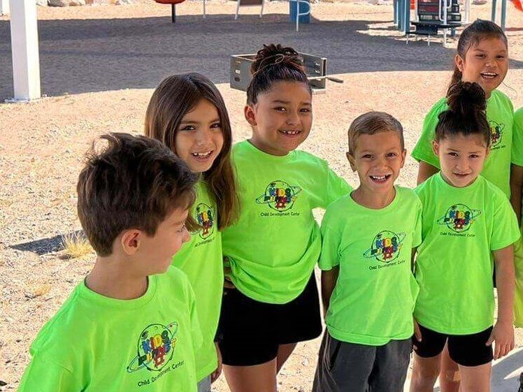 A group of children wearing neon green shirts are posing for a picture.