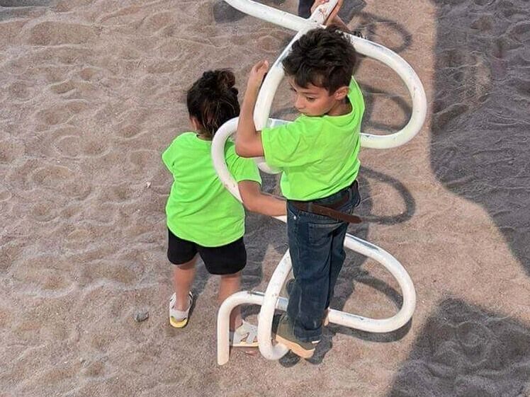 A boy and a girl are playing on a playground.