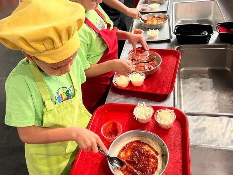 A group of children are preparing food in a kitchen.
