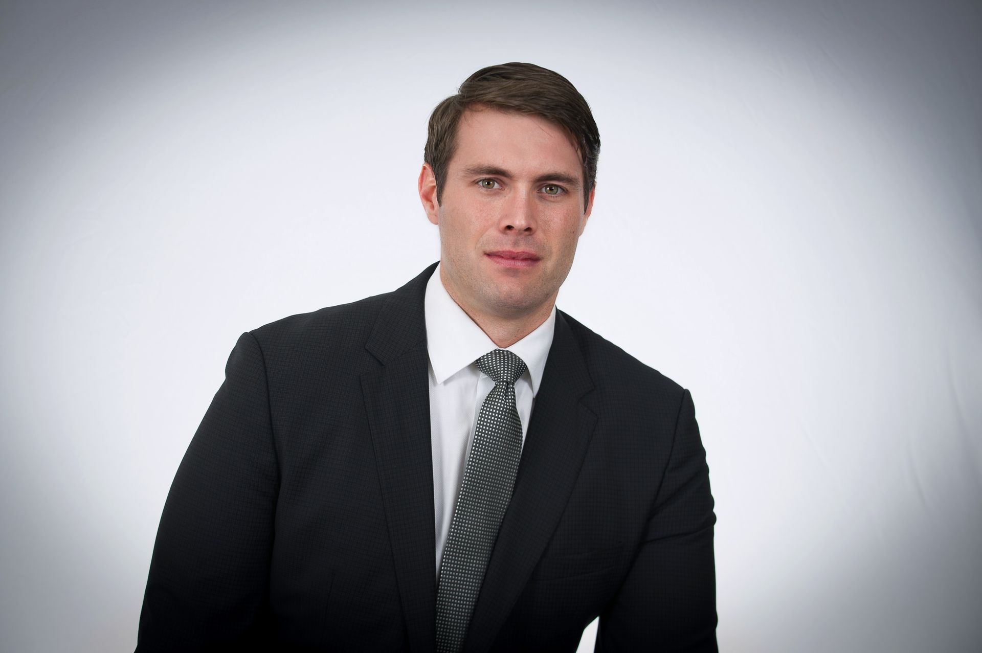 A man in a suit and tie is looking at the camera