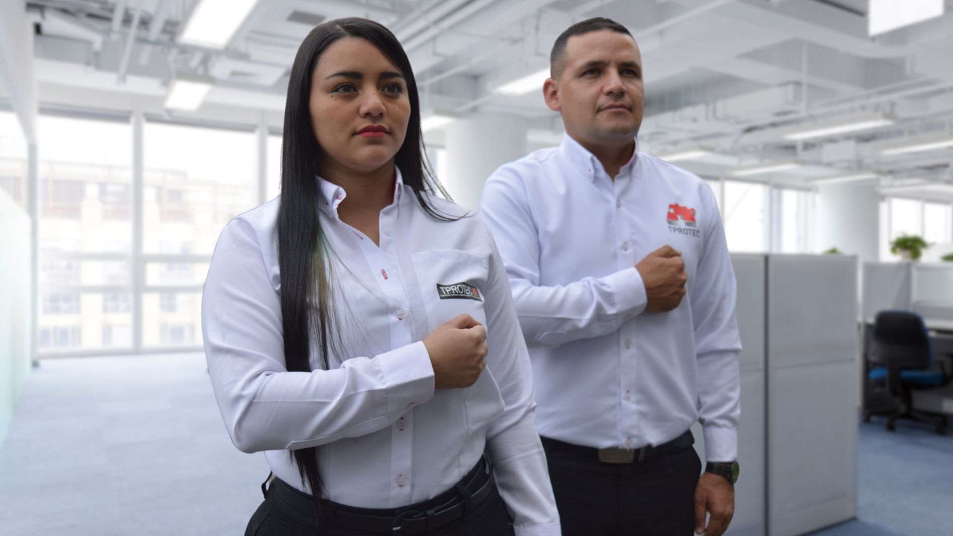 Un hombre y una mujer están parados uno al lado del otro en una oficina.