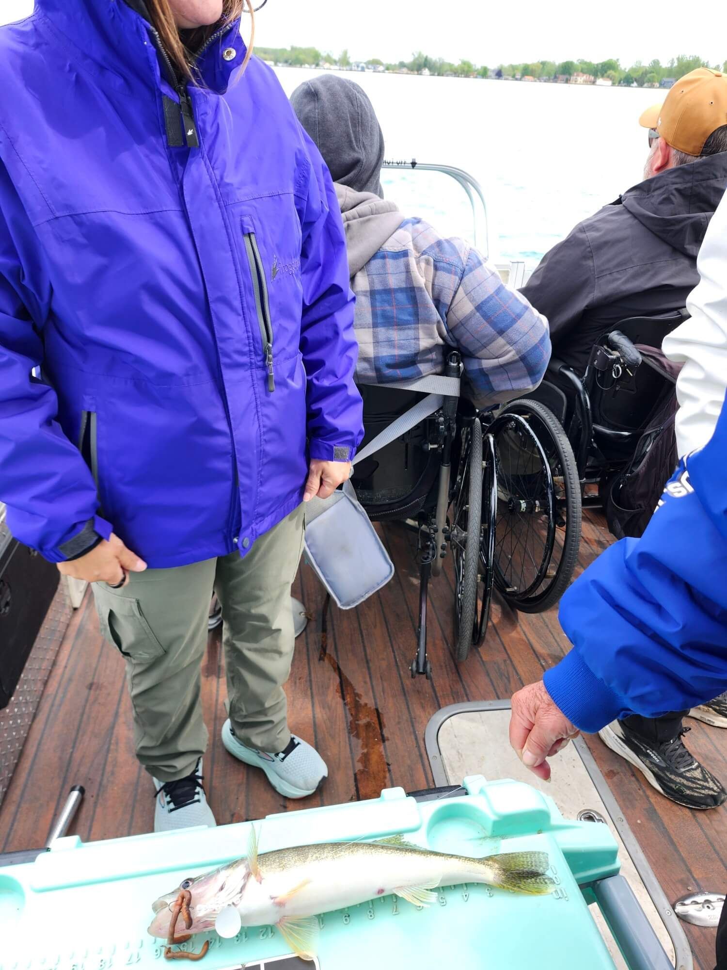 People on a boat with a fish on a tray in the foreground.