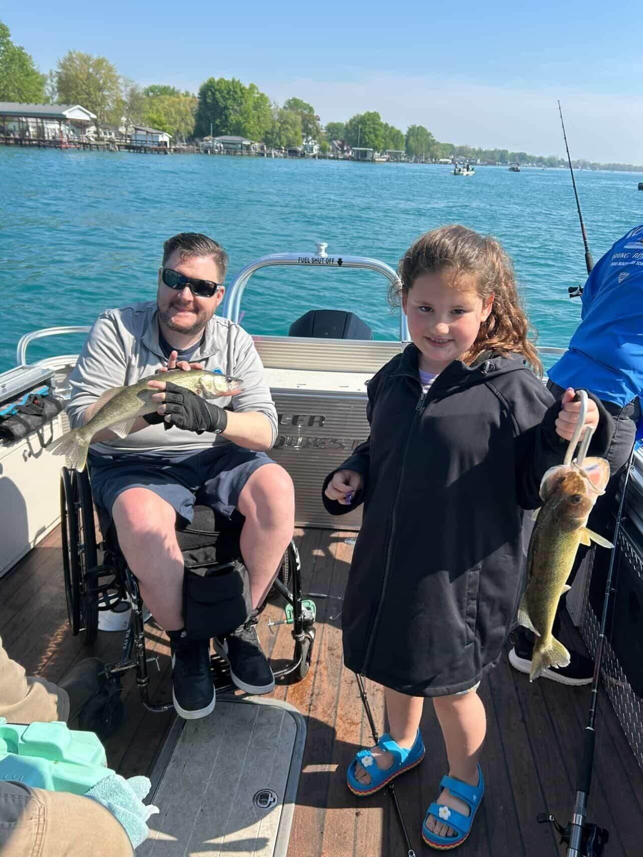 Two people on a boat holding up fish on a sunny lake.