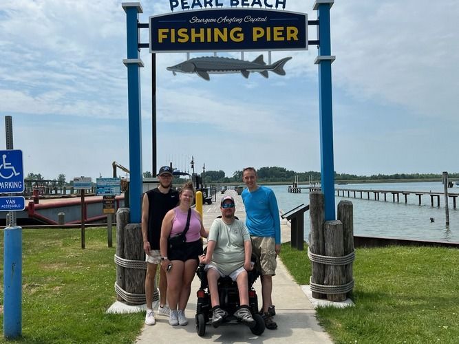Four people pose by a 