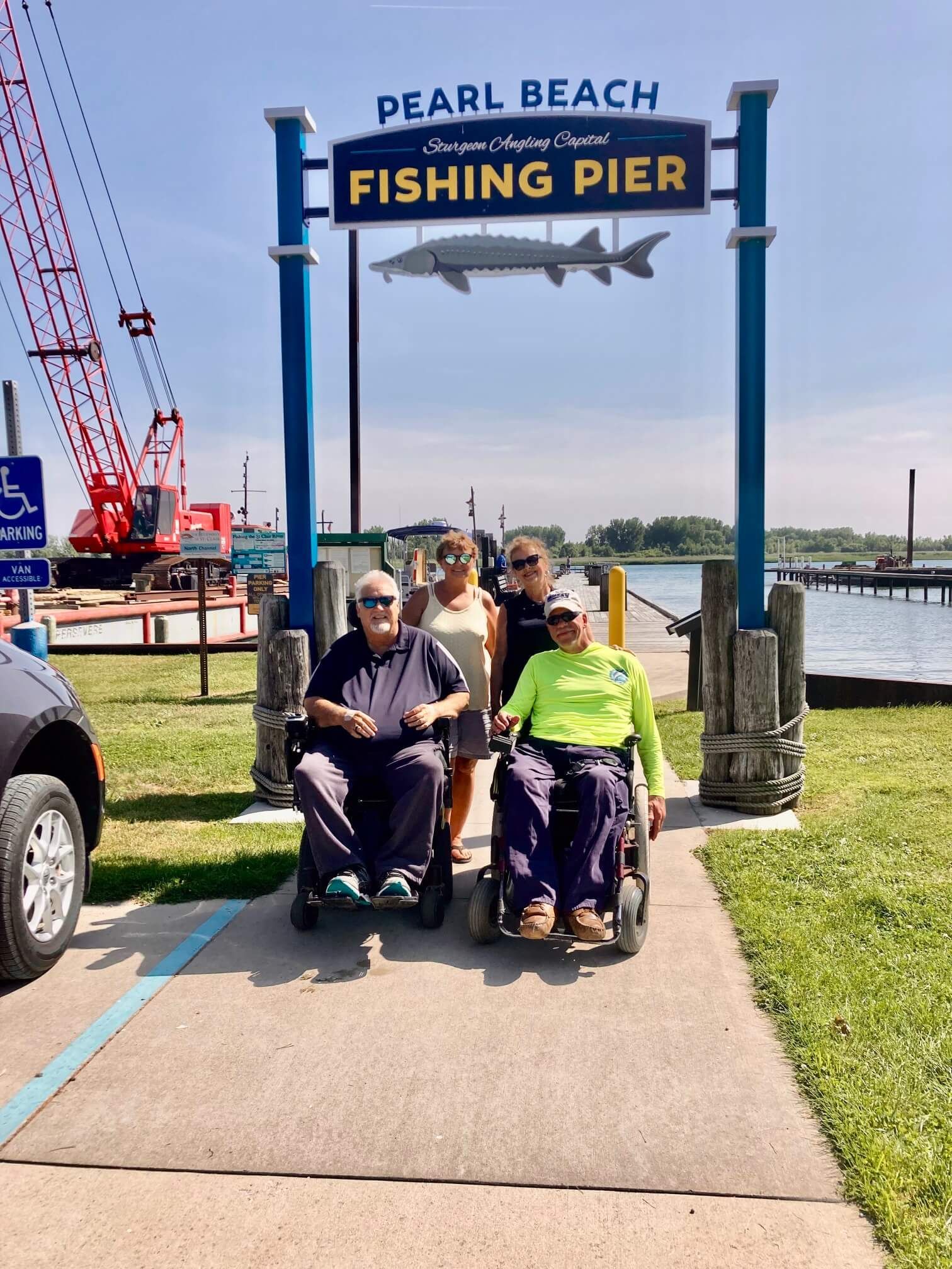 Two people in wheelchairs with two others at Pearl Beach Fishing Pier.