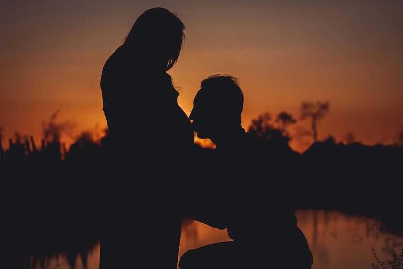 Expecting couple holding hands at sunset .Supported by Your Friend Your Doula KG Abilene TX