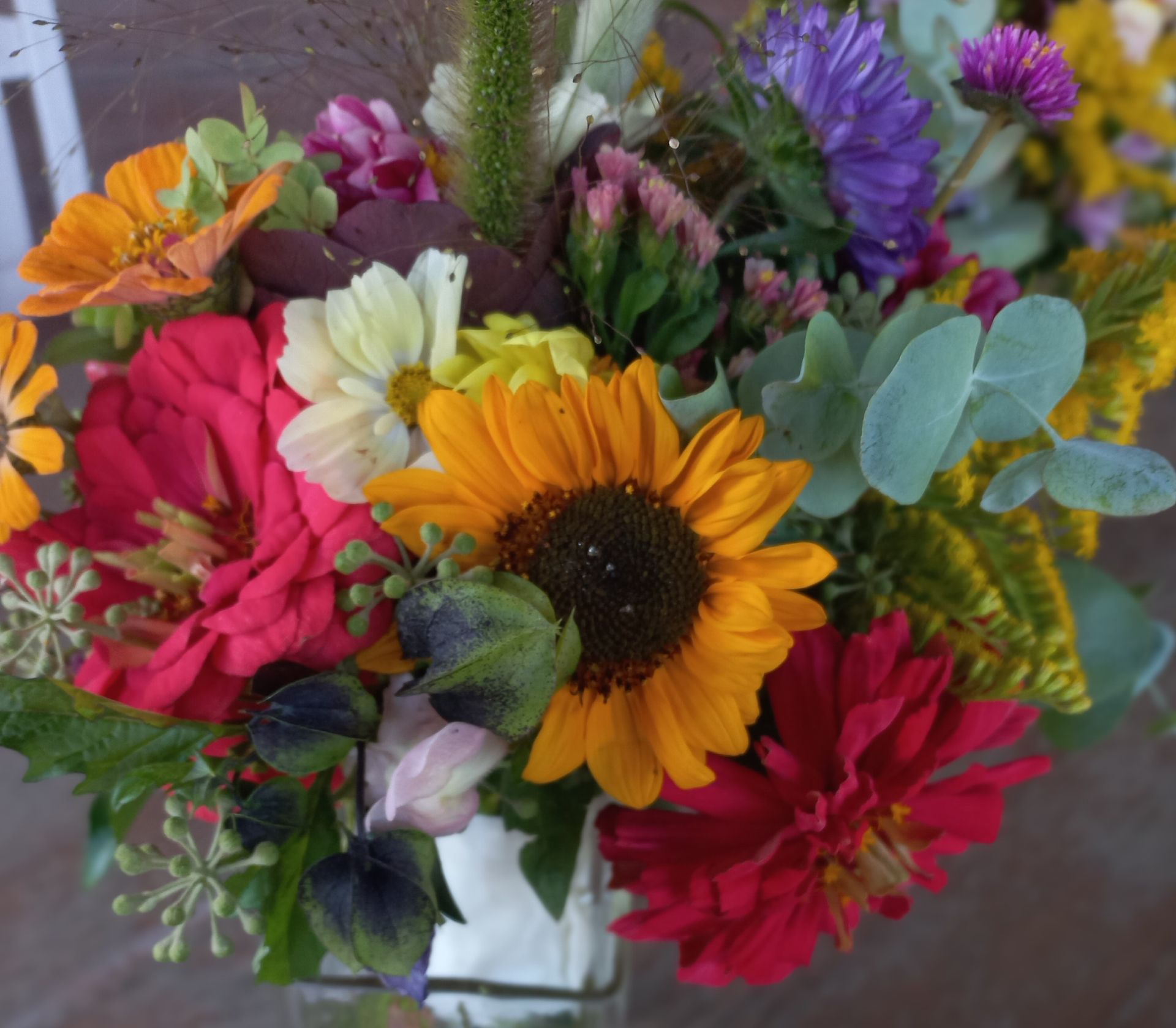 Kleurrijk bloemenboeket met zonnebloemen, dahlia's en eucalyptus.