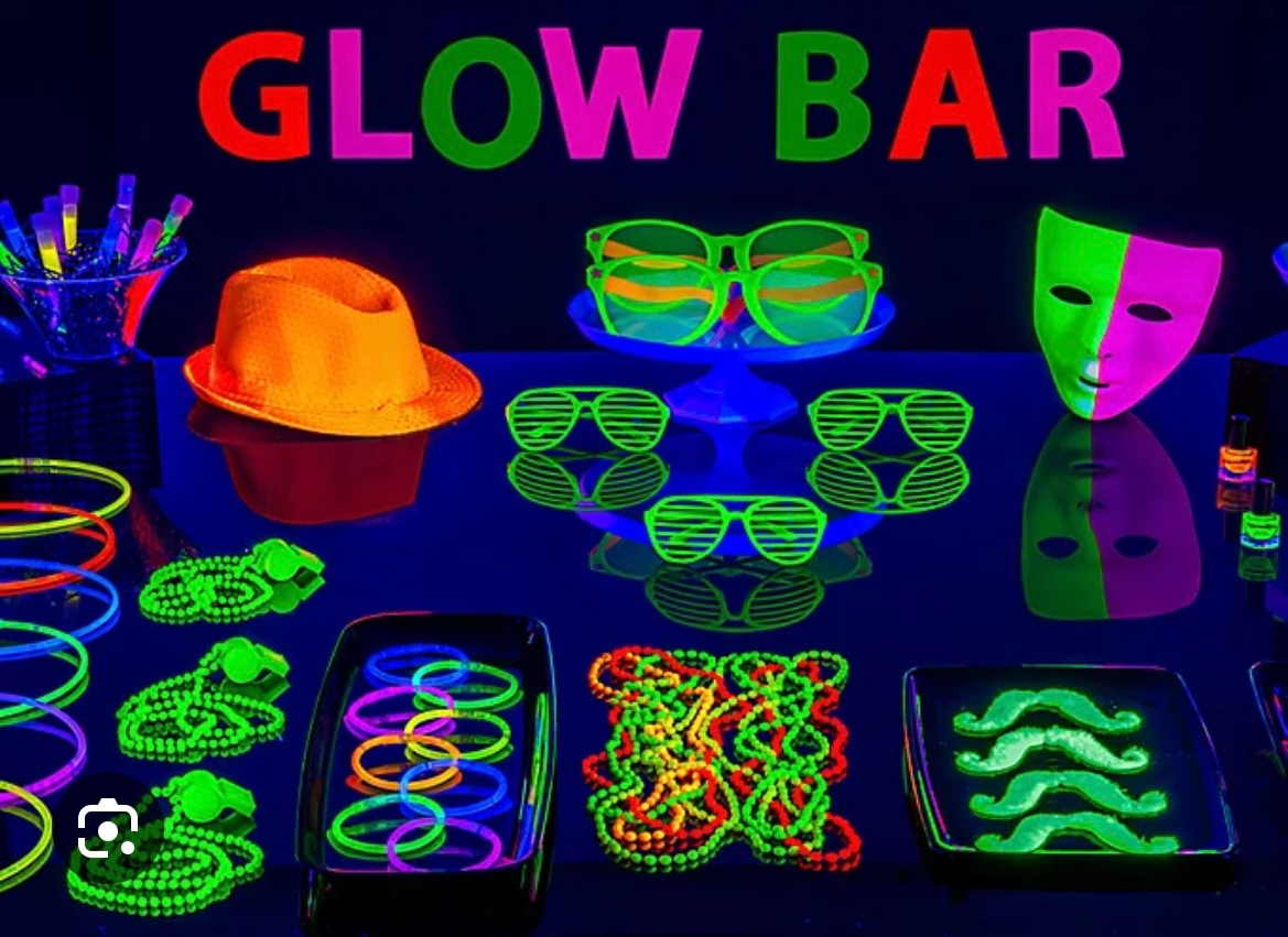 Glow in the dark party supplies are displayed on a table.