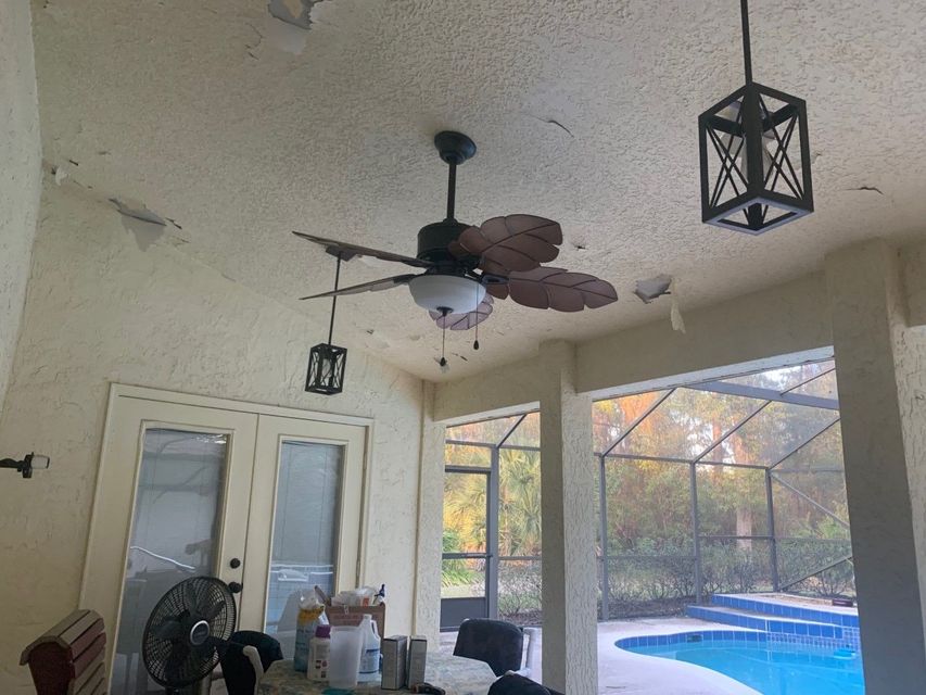 Covered patio with ceiling fan, hanging lanterns, and a view of a backyard pool