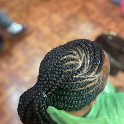 Braided hairstyle viewed from above, with intricate cornrows gathered into a low bun