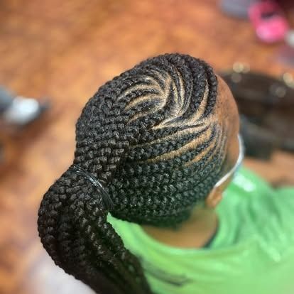 Top view of braided hair in a bun with cornrows, wearing a green shirt