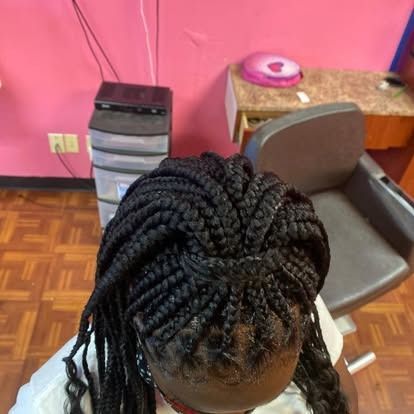 Top view of braided hair in a pink room with a chair, desk, and printer in the background