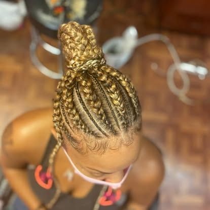 Top view of a braided hairstyle in a bun with gold beads on a woman indoors