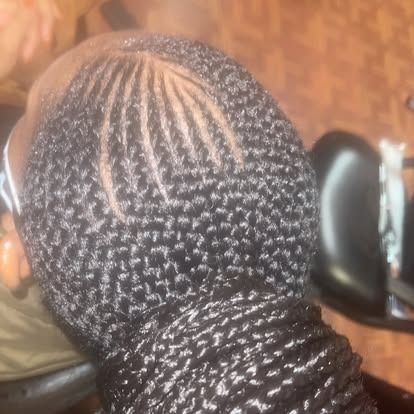 Close-up of braided hairstyle with neat cornrows and twists, viewed from above.