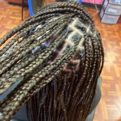 Close-up of braided hair with black and blonde highlights, viewed from above.