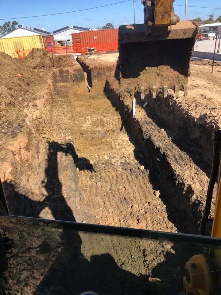 A Bulldozer Is Digging A Hole In The Ground — JJ's Excavator & Tipper Hire in Kingaroy, QLD