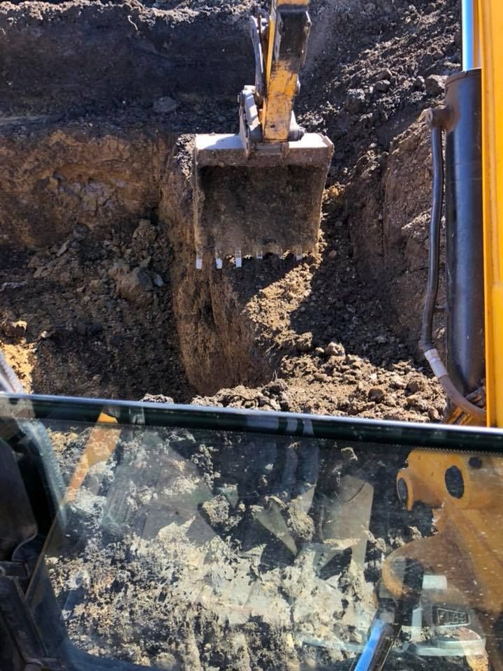 A Yellow Excavator Is Digging A Hole In The Ground — JJ's Excavator & Tipper Hire in Kingaroy, QLD