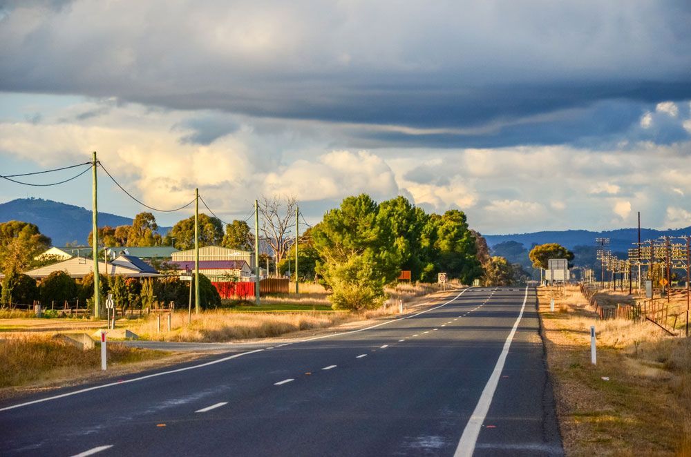 A Road Going Through A Small Town With Mountains In The Background — JJ's Excavator & Tipper Hire in Kumbia, QLD