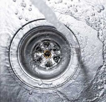 Running water drains down a stainless steel sink