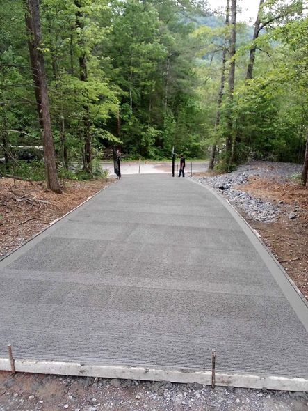 Freshly paved forest path with three people walking in the distance